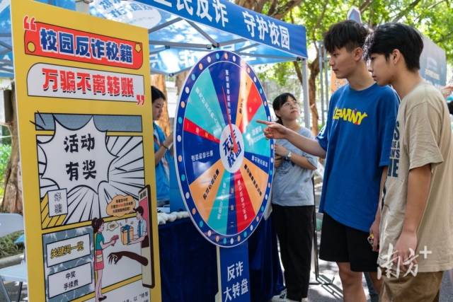 活动现场,大学生们玩游戏学防骗知识。 活动现场,大学生们玩游戏学防骗知识。