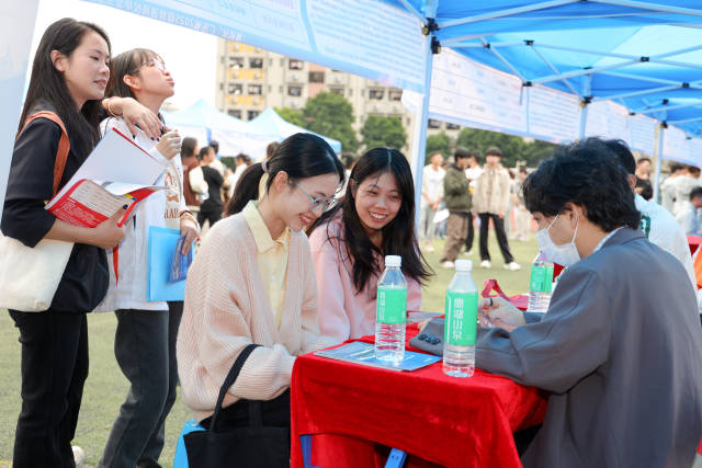 各个展位前聚集了众多求职的学生。